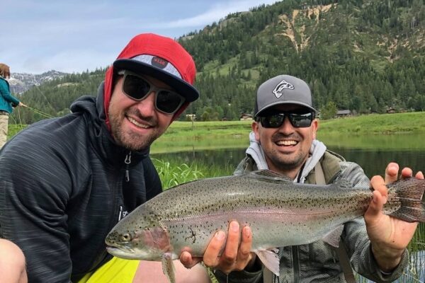 Instructor Sam with a giant fly fishing lesson, rainbow trout