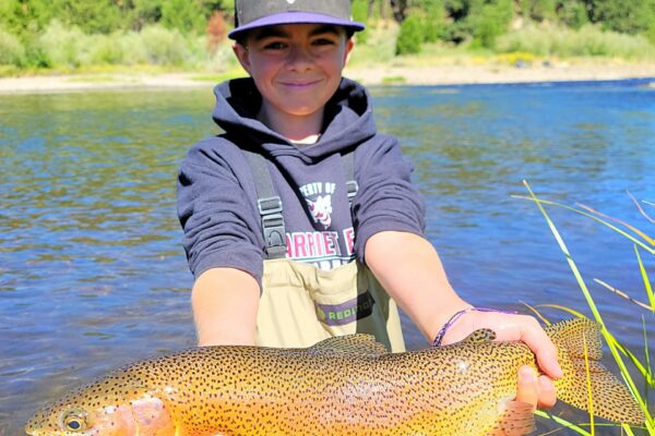A kid with a trophy little Truckee River rainbow trout ona full day guide trip