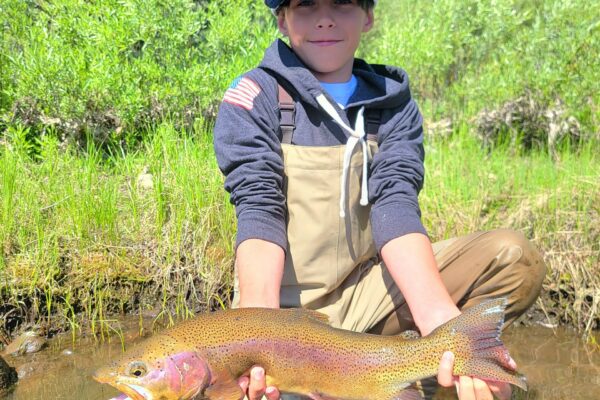 A kid landing a huge little Truckee rainbow
