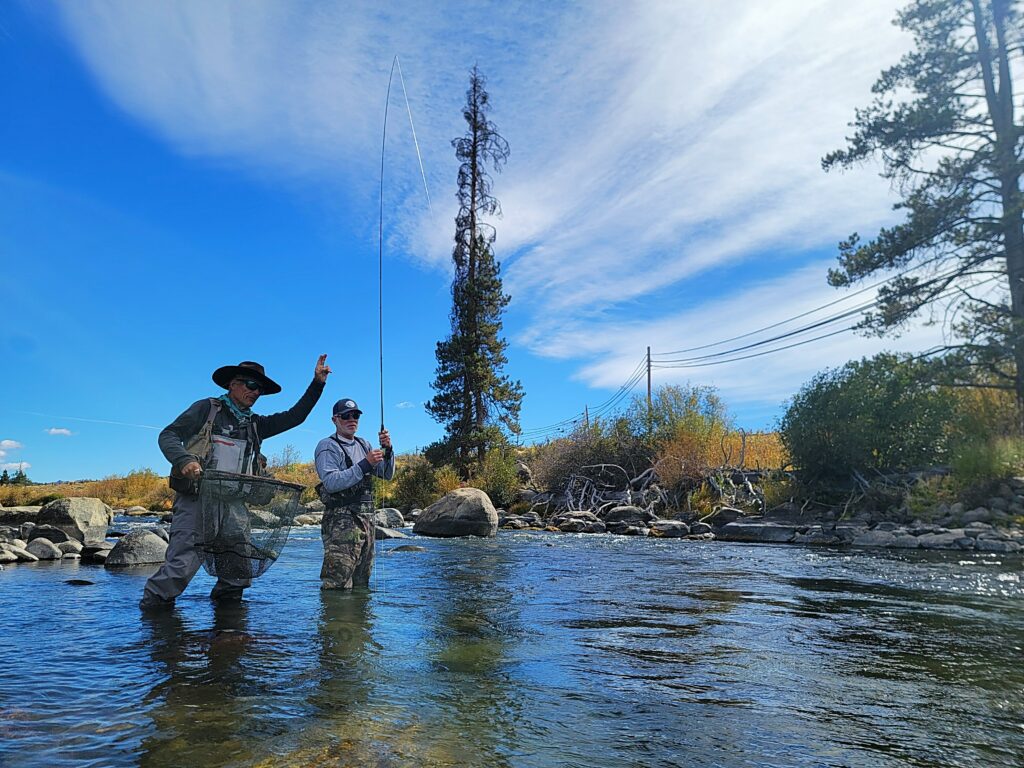 Fish on! Guide John Roberts helps an angler land a nice Truckee River bow!